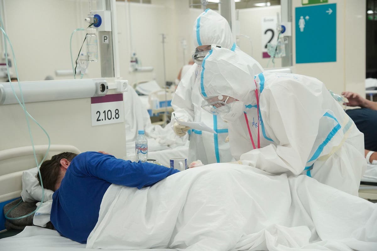 Medical specialists wearing personal protective equipment (PPE) take care of a patient at a temporary hospital set up, amid the outbreak of the coronavirus disease (COVID-19) in Moscow, Russia. (Reuters)