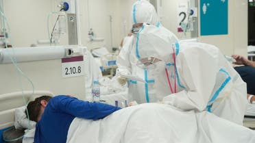 Medical specialists wearing personal protective equipment (PPE) take care of a patient at a temporary hospital set up, amid the outbreak of the coronavirus disease (COVID-19) in Moscow, Russia. (Reuters)