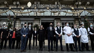 French workers wearing black armbands stand ouside the Intercontinental hotel in Bordeaux, south-western France on October 2, 2020. (AFP)