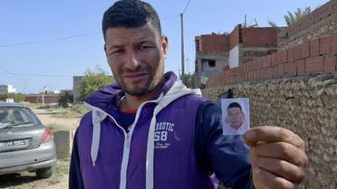 Yasin, the brother of the Nice assailant Brahim Aouissaoui, shows his picture in front of the family home in the Tunisian city of Sfax, on October 30. (AFP)