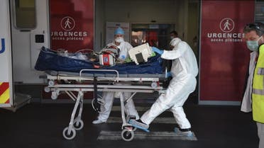 Medical staff carry a patient infected with the Covid-19 disease into Strabourg hospital's emergency unit following his arrival by plane from the Lyon's area on November 6, 2020 in Strasbourg, eastern France. (AFP)