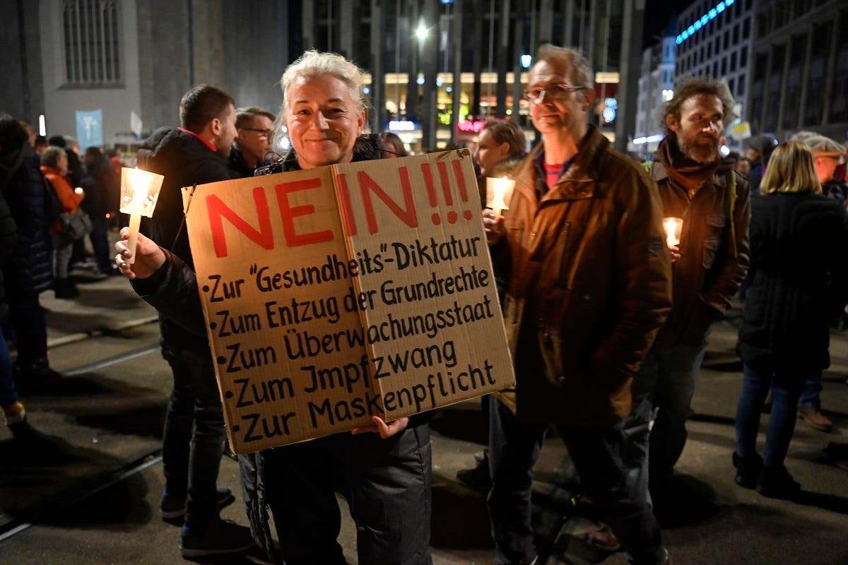 A participant holds up a placard rejecting the government’s measures to curb the coronavirus during a protest in Leipzig, eastern Germany, on November 7, 2020. (AFP)