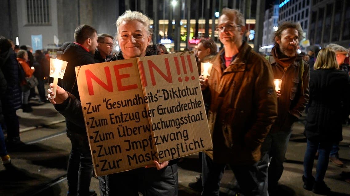 A participant holds up a placard rejecting a ‘health dictatorship, the withdrawal of fundamental rights, state supervision, compulsory vaccination and wearing of masks’ during a protest in Leipzig, eastern Germany, on November 7, 2020. (John Macdougall/AFP)