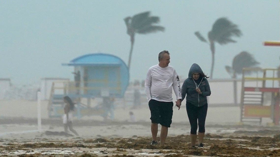 A couple walks along the beach during a downpour, Sunday, Nov. 8, 2020, on Miami Beach, Florida's famed South Beach. (AP)