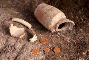 A small pottery jug with four pure gold coins found inside it by the Israel Antiquities Authority are displayed at the archaeological rescue excavation site in the Old City of Jerusalem, on November 9, 2020. (Menahem Kahana/AFP)