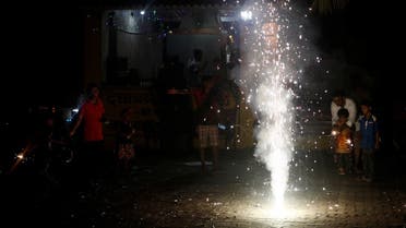 People watch as firecrackers burn on a street during Diwali, the Hindu festival of lights, in Mumbai, India. (Reuters)