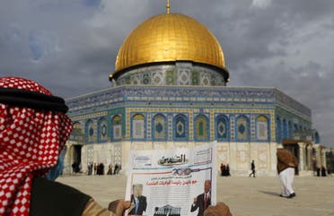 A Palestinian man reads the front page of Al-Quds newspaper, headlined in Arabic "Joe Biden the new US President" in front of the Dome of the Rock in the al-Aqsa mosque compound in East Jerusalem on November 8, 2020. (AFP)