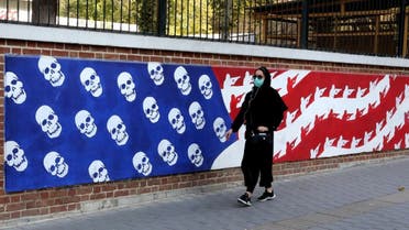An Iranian woman walks past a mural painted on the outer walls of the former US embassy in the Iranian capital Tehran, on November 4, 2020. (AFP)