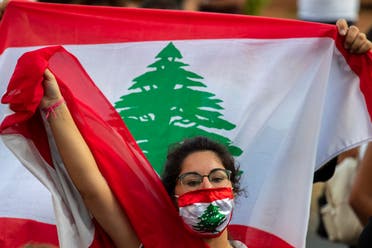 An anti-government protester shouts slogans while wearing a mask with the colors of the Lebanese flag in Beirut, Lebanon, Thursday, July 2, 2020. (AP)
