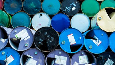 Old chemical barrels. Blue, green, and red oil drum. Steel oil tank. Toxic waste warehouse. Hazard chemical barrel with warning label. Industrial waste in metal drum. Hazard waste storage in factory. stock photo