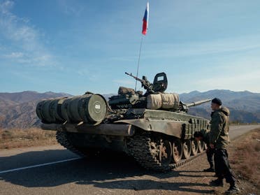 Service members of the Russian peacekeeping troops stand next to a tank near the border with Armenia in the region of Nagorno-Karabakh, November 10, 2020. (Reuters) 