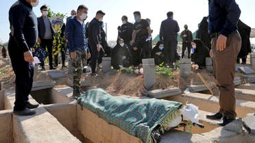 Mourners attend the funeral of a person who died from COVID-19 at the Behesht-e-Zahra cemetery on the outskirts of Tehran, Iran, Sunday, Nov. 1, 2020. The cemetery is struggling to keep up with the coronavirus pandemic ravaging Iran, with double the usual number of bodies arriving each day and grave diggers excavating thousands of new plots. (AP Photo/Ebrahim Noroozi)