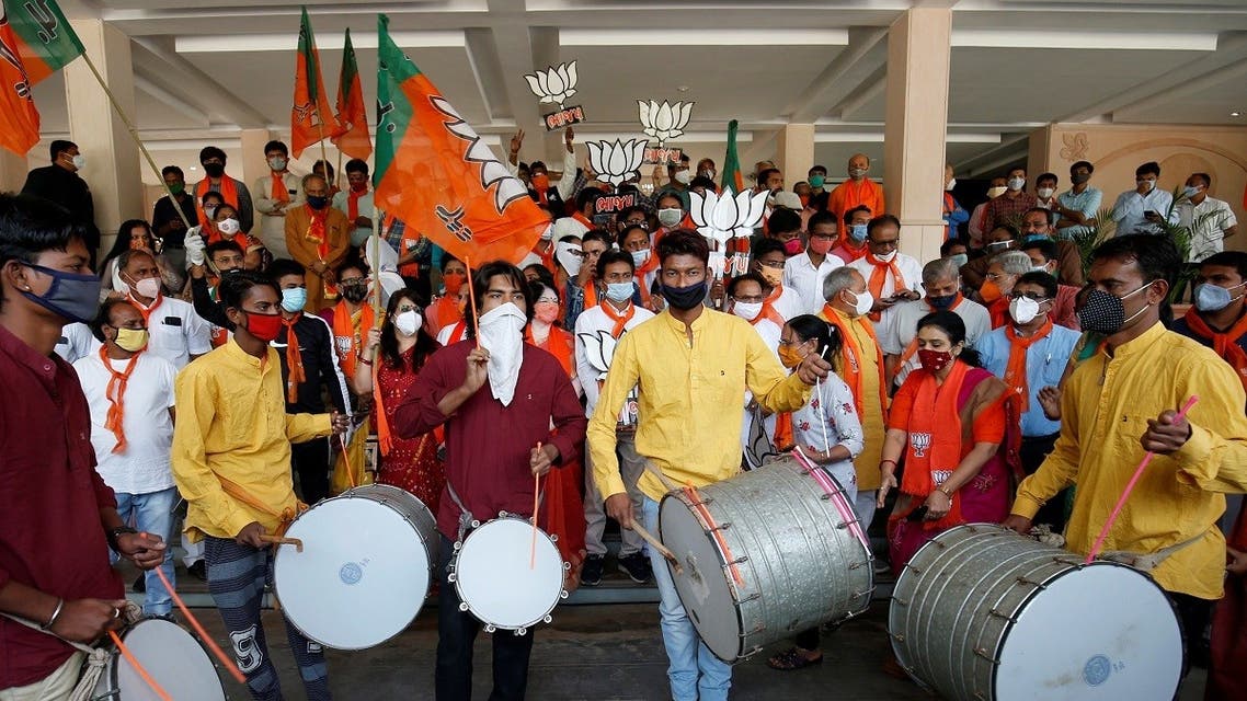 Supporters of India’s ruling Bharatiya Janata Party (BJP) hold their party symbol and flags as they gather to celebrate after learning of the initial poll results of the Bihar state assembly election and by-elections in Gujarat, Karnataka and Madhya Pradesh states, in Gandhinagar, India, on November 10, 2020. (Reuters)
