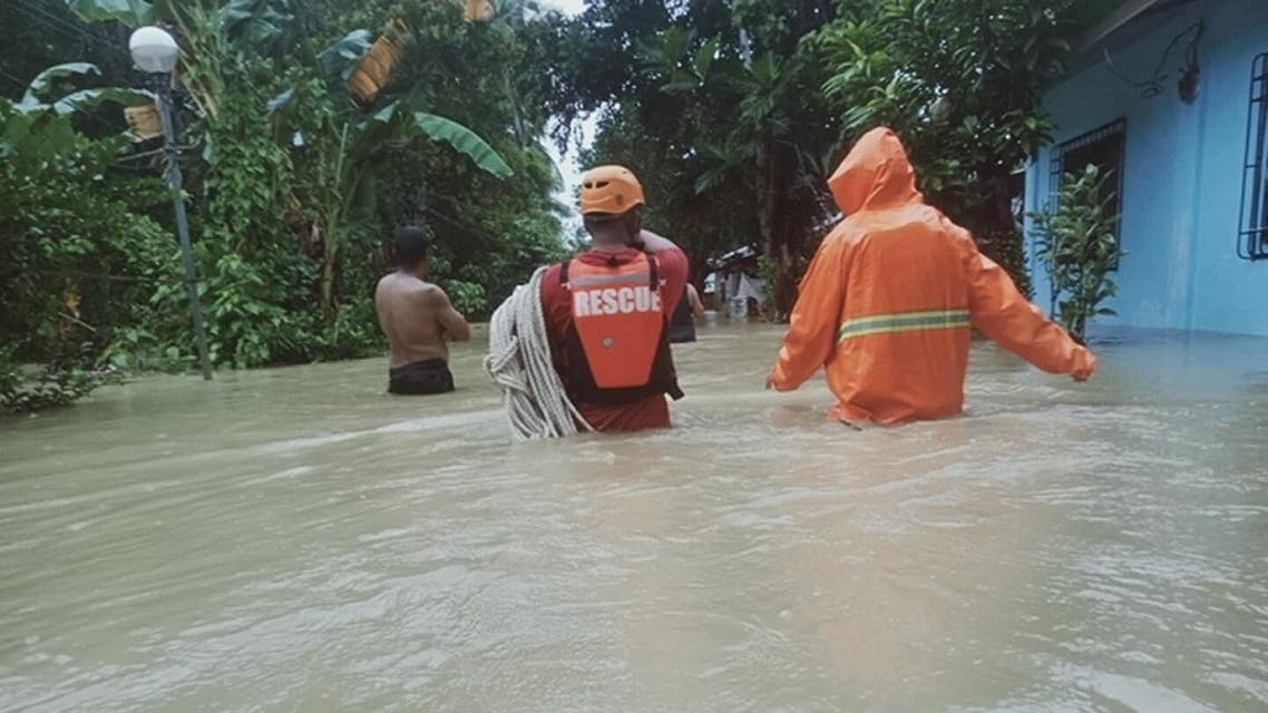 Members of a rescue team walk in floodwater in Caluag Town, Quezon province, Philippines, on October 21, 2020, in this picture obtained from social media. Municipal Disaster Risk Reduction and Management Office – Caluag. (Reuters)