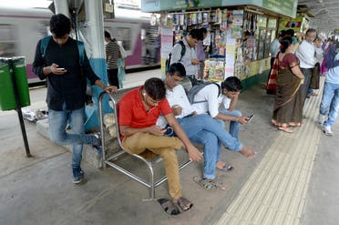 A file photo shows Indians surf the internet on their phones at a free wi-fi zone inside a suburban railway station in Mumbai. (AFP)