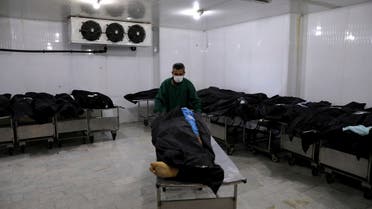 An Iranian cemetery worker prepares the body of a man who died from COVID-19, in a morgue at the Behesht-e-Zahra cemetery on the outskirts of the Iranian capital, Tehran, Iran, Sunday, Nov. 1, 2020. Mortuary attendants prepare each body for the ritual washing required for the Muslim dead. During the pandemic, that now includes the use of disinfectants. (AP Photo/Ebrahim Noroozi)