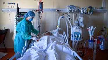 A member of the medical staff tends to a patient at an intensive care unit for patients infected with Covid-19 near Paris on November 4, 2020. (AFP)