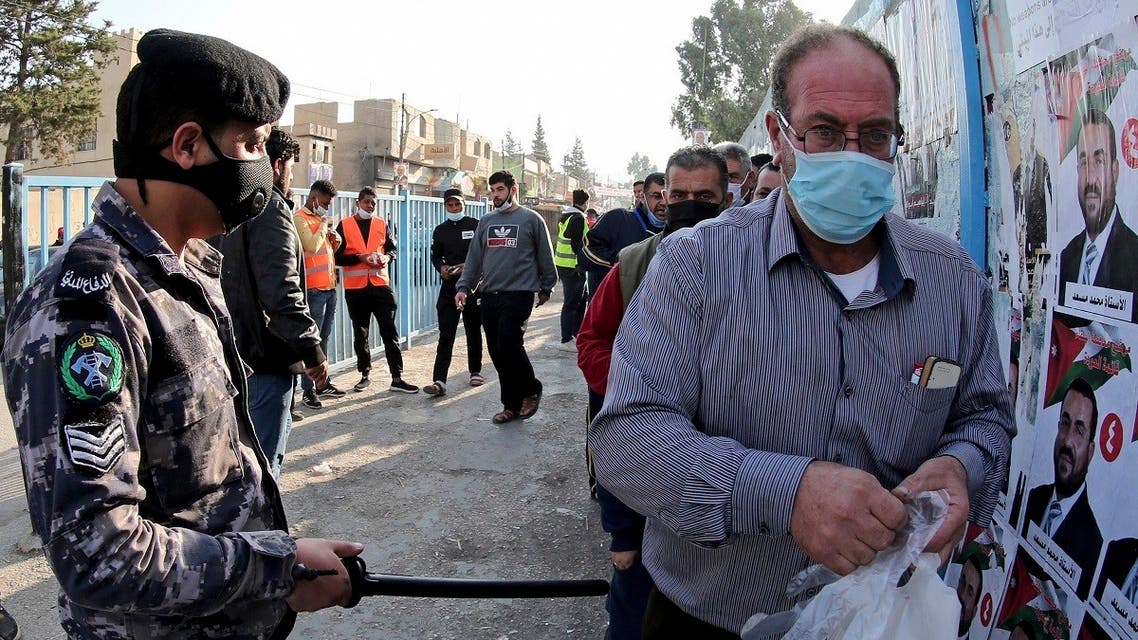 A man is checked with a metal detector outside a polling station as Jordanians begin voting in a parliamentary election overshadowed by the coronavirus pandemic, in Amman, Nov. 10, 2020. (AP)