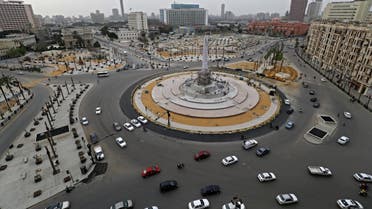 Cars drive in the Egyptian capital Cairo's Tahrir square, shortly before the first day of a two-weeks night-time curfew imposed by the authorities to contain the spread of the coronavirus began on March 25, 2020. (AFP)
