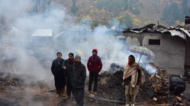 People stand near their destroyed houses in Tehjain village a day after cross-border shelling between Pakistani and Indian forces at the Line of Control (LoC), the defacto border between Pakistan and India,in Neelum Valley of Pakistan-administered Kashmir on November 14, 2020. Indian and Pakistani forces on November 13 waged their biggest artillery battle of the past year, leaving more than 13 dead and dozens wounded on both sides of their disputed Kashmir frontier, officials said.