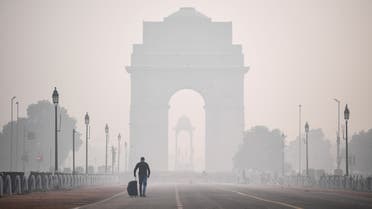 A man walks along the Rajpath street near India Gate amid smoggy conditions a day after Diwali, the Hindu festival of lights, in New Delhi on November 15, 2020. 