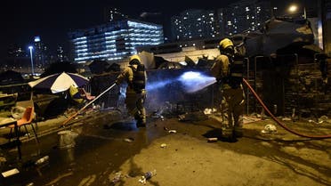 Fire fighters extinguish fire on the barricades in the main road next to the Polytechnic University of Hong Kong in Hung Hom district of Hong Kong on November 16, 2019. (Ye Aung Thu/AFP)