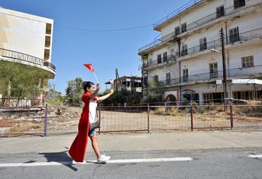 شابة ترفع علمَيْ تركيا وجمهورية قبرص التركية في منتجع فاروشا
