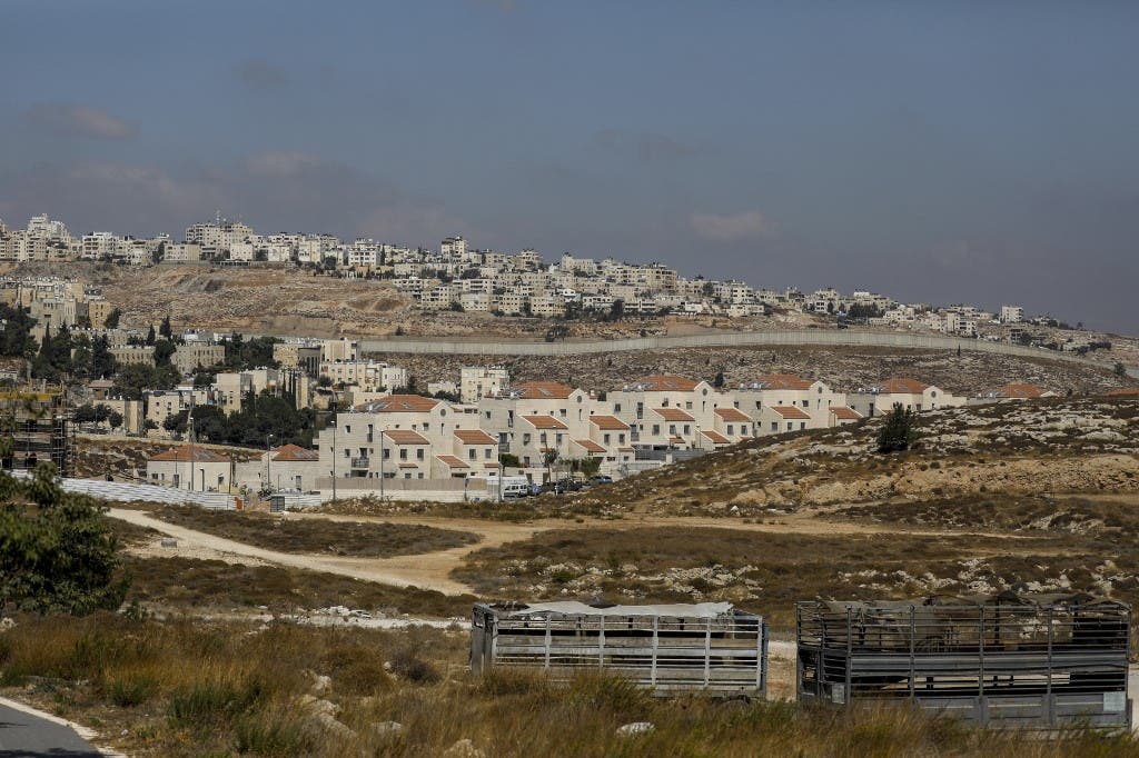 Israel's controversial concrete barrier (C) separating the Jewish settlement of Neve Yaakov (foreground) in the northern part of east Jerusalem and the Palestinian area of al-Ram (background) in the occupied West Bank. (AFP)