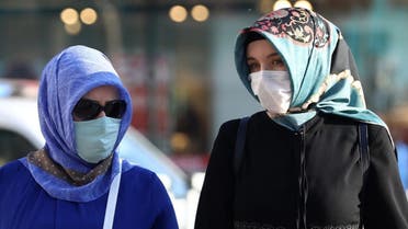 Two Muslim women wear their protective face masks while walking along the street in Ankara on September 18, 2020. (AFP)