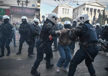 Riot police officers tussle a protester during a demonstration staged by members of the Greek Communist party and leftists to commemorate the 1973 uprising against the military junta, Athens, November 17, 2020. (Louisa Gouliamaki/AFP)