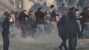 Protesters flee after riot police used tear gas and water cannons against them during a demonstration staged by members of the Greek Communist party and leftists to commemorate the 1973 uprising against the military junta, in central Athens, on November 17, 2020. (Louisa Gouliamaki/AFP)