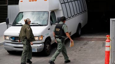 In this March 19, 2019 file photo, a van carrying asylum seekers from the border is escorted by security personnel as it arrives to immigration court, in San Diego. (AP)