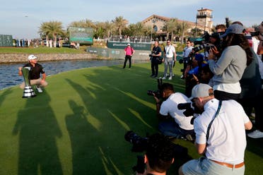 Cameramen film Graeme McDowell from Northern Ireland as he celebrates the trophy after he wins the final round of the Saudi International at Royal Greens Golf and Country Club on Feb. 2, 2020. (AP)