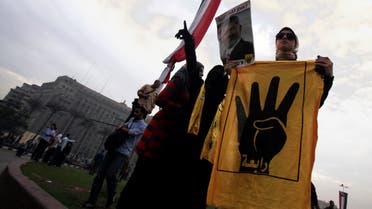Pro-Mursi university students and supporters of the Muslim Brotherhood display a poster of ousted President Mohamed Mursi at Tahrir Square in Cairo December 1, 2013. (Reuters)