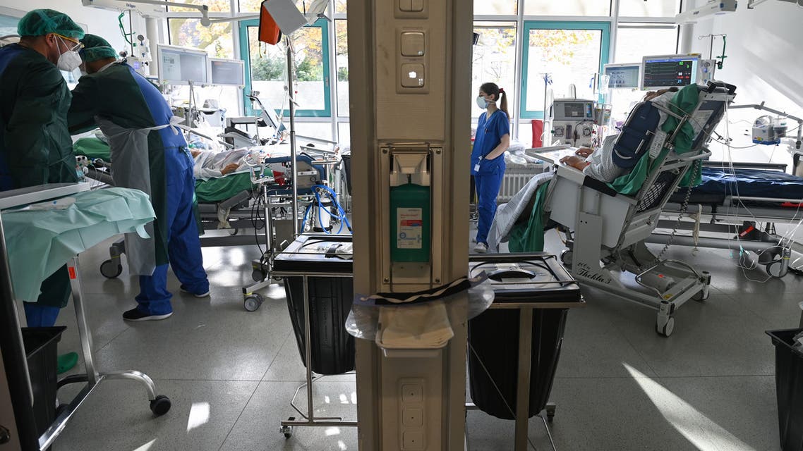Nursing staff prepare the use of a lung machine for a Covid-19 patient in the Covid-19 intensive care unit of the university hospital (Universitaetsklinikum) in Essen, western Germany, on October 28, 2020. German Chancellor Angela Merkel is seeking drastic new curbs, including fresh shutdowns hitting leisure, sports and the food and drink sectors, as she holds crisis talks with Germany's regional leaders to halt surging coronavirus infections and save the Christmas holiday season.