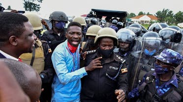 Ugandan presidential candidate Robert Kyagulanyi also known as Bobi Wine is led into a vehicle by riot policemen in Luuka district, eastern Uganda, on November 18, 2020. (Reuters)