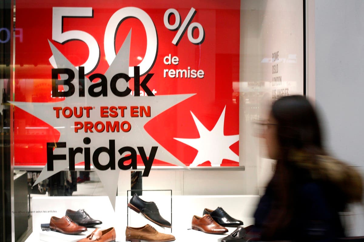A woman walks past a sticker promoting the Black Friday in the business district of Paris, France. (File photo: AP)