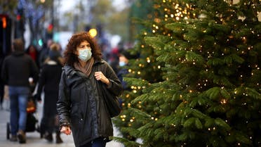 A woman walks past Christmas trees on Oxford Street, amid the coronavirus disease (COVID-19) outbreak, in London, Britain, November 21, 2020. (Reuters)