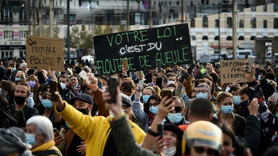 Demonstrators holds a placard with a play on words using the word blur out to read This is a mockery during a rally on the Vieux-Port, called by the Yellow Vests movement (Gilets Jaunes) to protest against the global security draft law seeking to limit filming of police officers on duty, in Marseille, on November 21, 2020. (AFP)