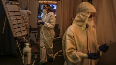 Healthcare workers attend patients at a campaign tent where they carry out COVID-19 tests outside the Sao Joao Hospital in Porto on October 22, 2020. (AFP)