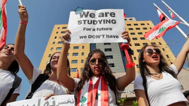Lebanese students wave the national flag and chant slogans as they gather outside the Ministry of Education and Higher Education during ongoing anti-government protests, in the capital Beirut on November 8, 2019. (AFP)