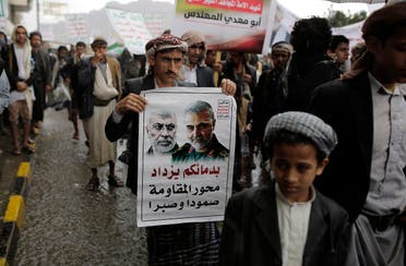 A Yemeni Shia Houthi holds a poster of Iraqi militia commander Abu Mahdi al-Muhandis and Iranian military commander Qassem Soleimani during a protest in Sanaa, Yemen, Jan. 6, 2020. (AP)