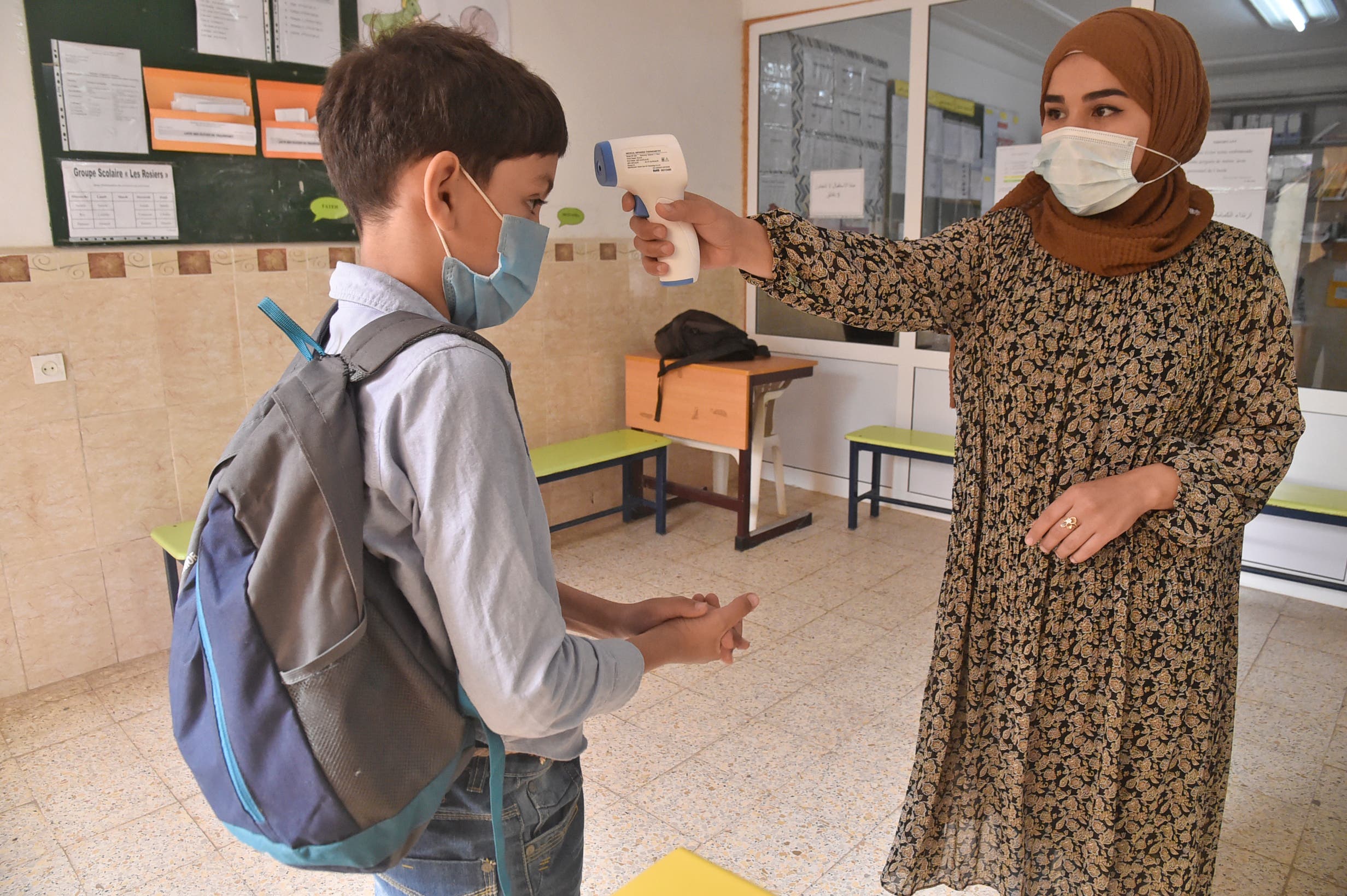 قياس حرارة الطلاب والتزام بالكمامات للوقية من كورونا في إحدى مدارس الجزاير