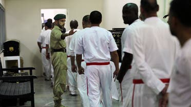 A policeman directs prisoners leaving their daily shift at the Inmates Education and Training Department of the Central Prison in Dubai on July 26, 2017. (AP)