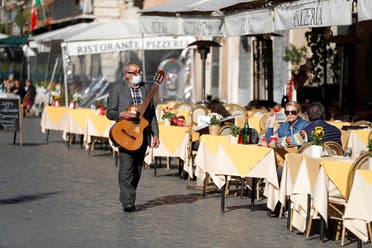 A musician walks in Piazza Navona square, as the spread of the coronavirus disease (COVID-19) continues, in Rome, Italy November 23, 2020. (Reuters/Yara Nardi)