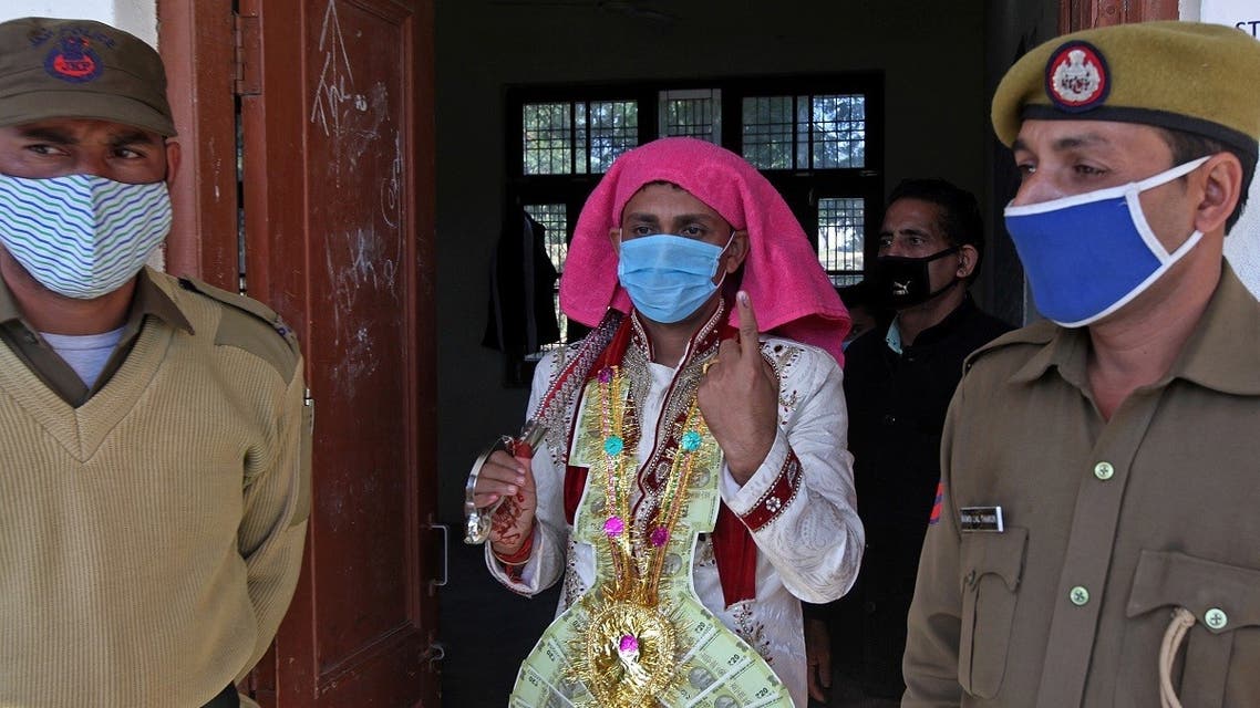 Newly married Mangat Ram, 27, shows his ink marked finger after casting his ballot during the first phase of the District Development Council (DDC) and Panchayat by-elections at a polling station in Akhnoor near Jammu on November 28, 2020. (Rakesh Bakshi/AFP)