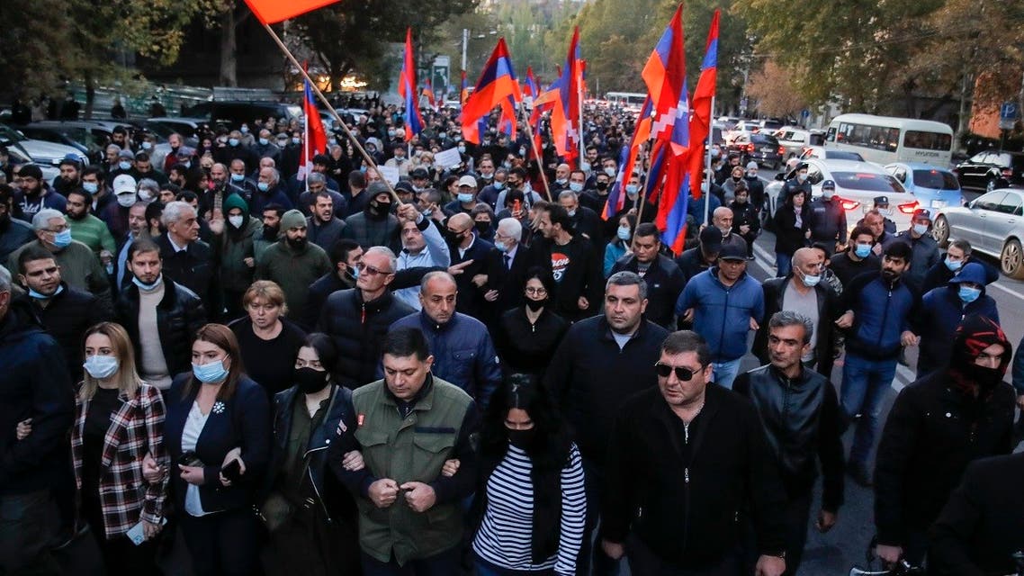 Protesters with Armenian flags walk along a street during a protest against an agreement to halt fighting over the Nagorno-Karabakh region, in Yerevan, Armenia, Thursday, Nov. 12, 2020. (AP/Dmitri Lovetsky)