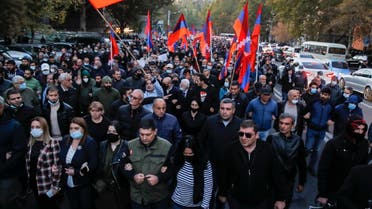 Protesters with Armenian flags walk along a street during a protest against an agreement to halt fighting over the Nagorno-Karabakh region, in Yerevan, Armenia, Thursday, Nov. 12, 2020. (AP/Dmitri Lovetsky)