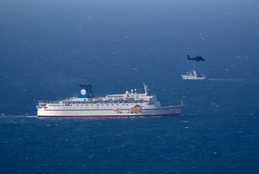 An Israeli military naval ship and an Israeli air force helicopter operate next to a cruise ship off the coast of Haifa on April 25, 2013. (AP)