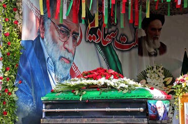 A handout picture provided by Iran’s Defense Ministry on November 30, 2020 shows the coffin of slain top nuclear scientist Mohsen Fakhrizadeh in front of a large display depicting Fakhrizadeh next to Iran’s supreme leader Ali Khamenei during the funeral ceremony in Tehran. (AFP)
